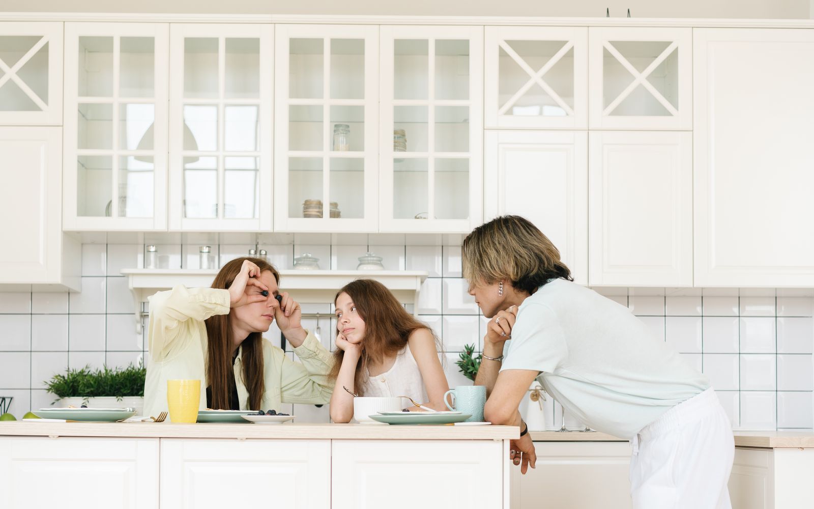 Ouders en jongere samen in de keuken, een speels en warm familiemoment